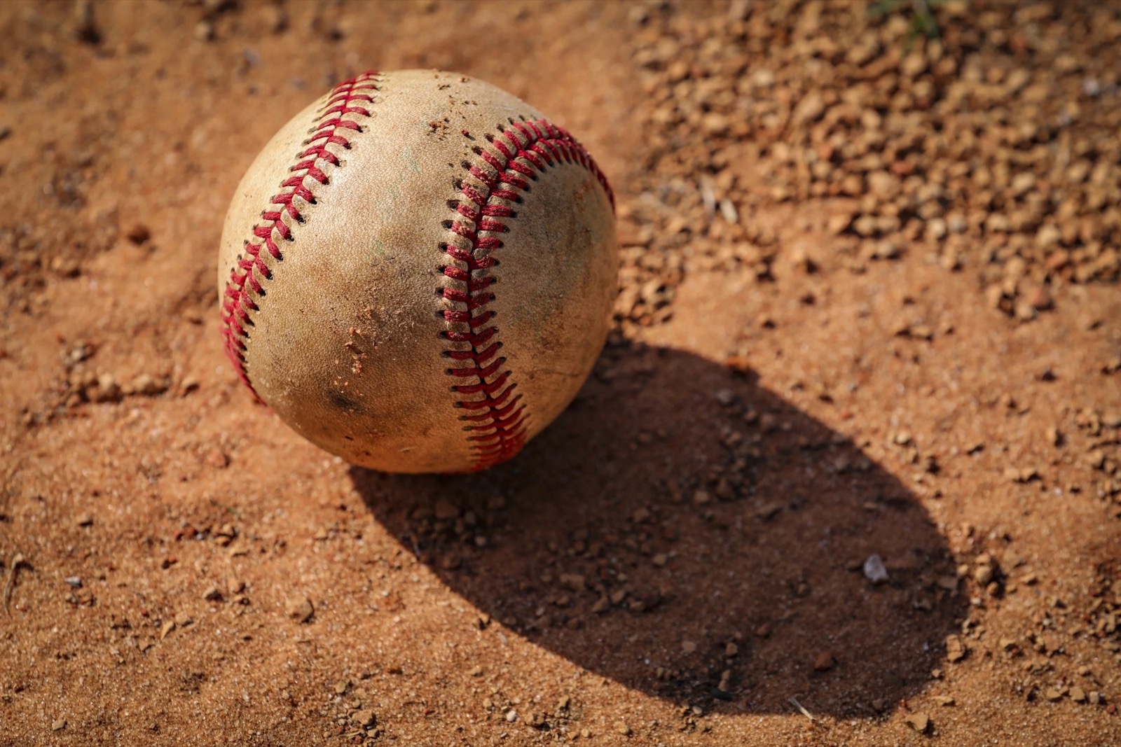 A game-worn baseball on the dirt